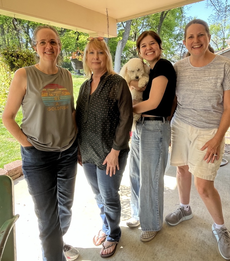 Professional home cleaning team in Nashville TN posing together outdoors with a small white dog